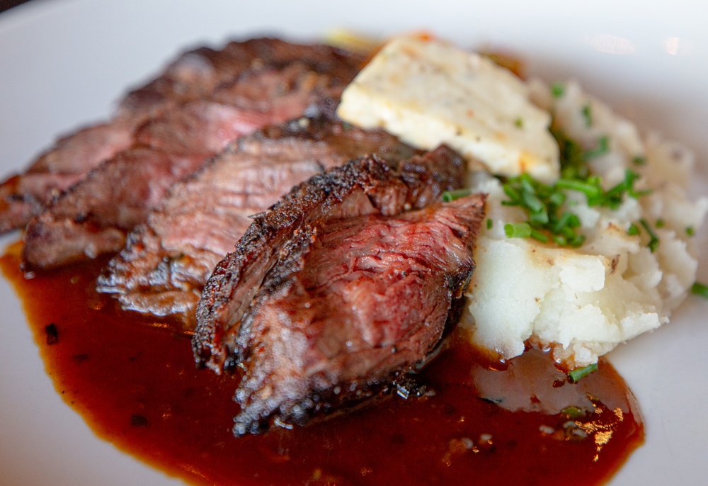 hanger steak plated with mashed potatoes and butter on top